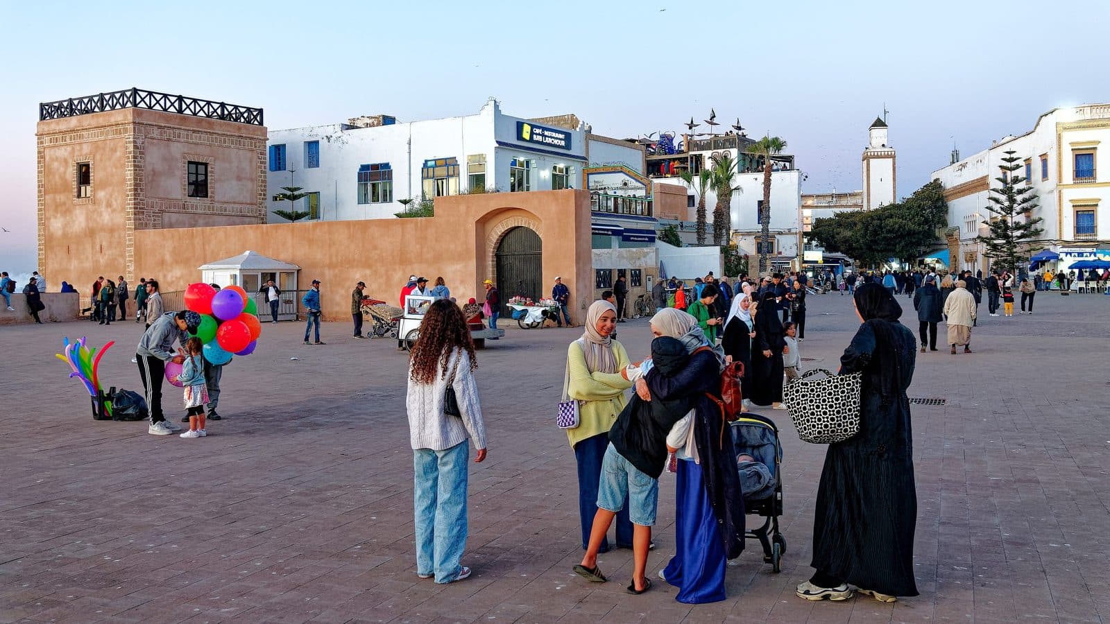 Familles et enfants avec des ballons sur la place Moulay Hassan à Essaouira en fin de journée