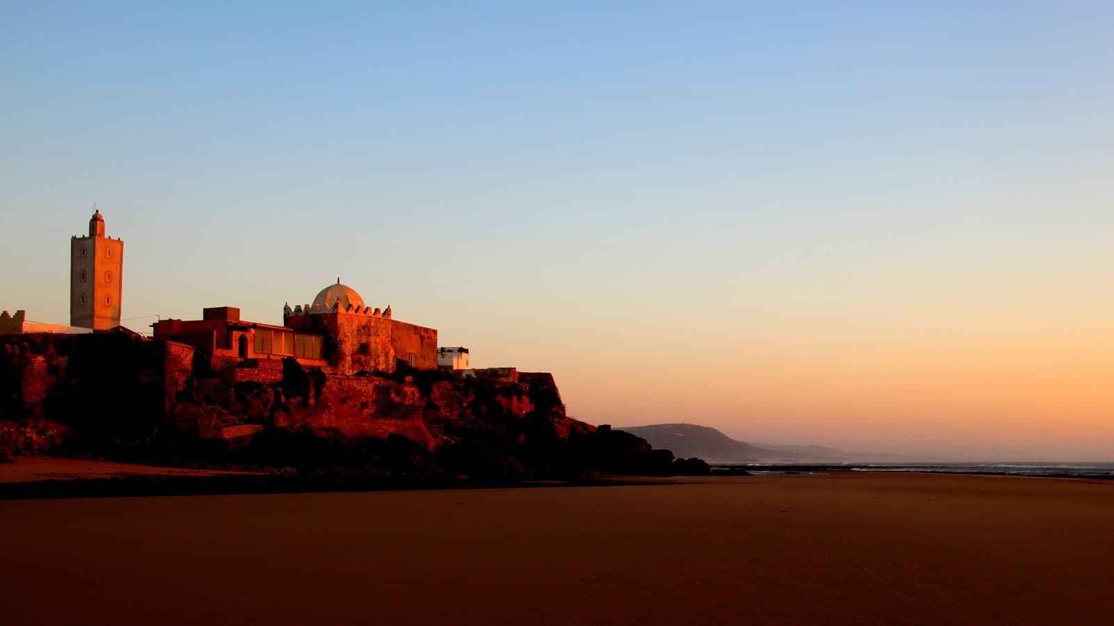Le village de Moulay Bouzerktoune et son minaret au coucher du soleil au bord de l’océan