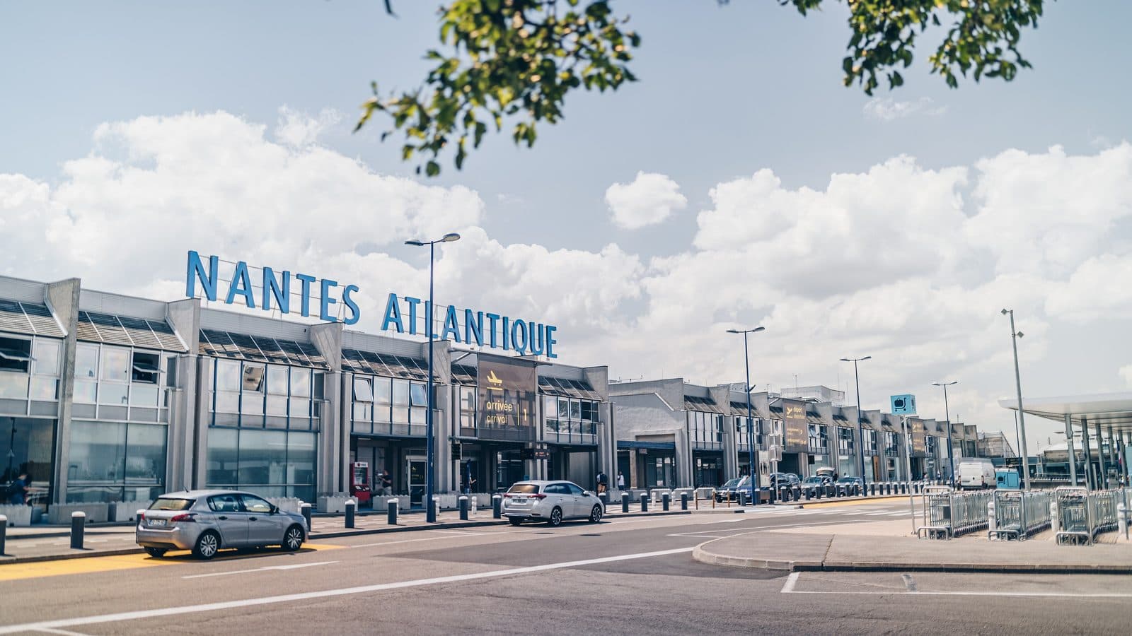 Façade du terminal de l'aéroport Nantes Atlantique sous un ciel bleu
