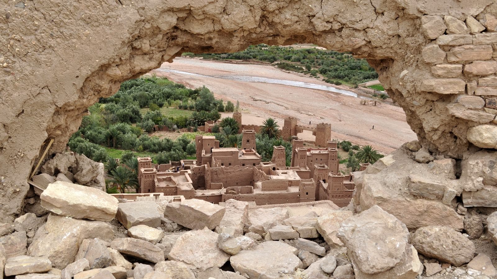 The earthen houses of the ksar of Aït Benhaddou seen through a stone archway