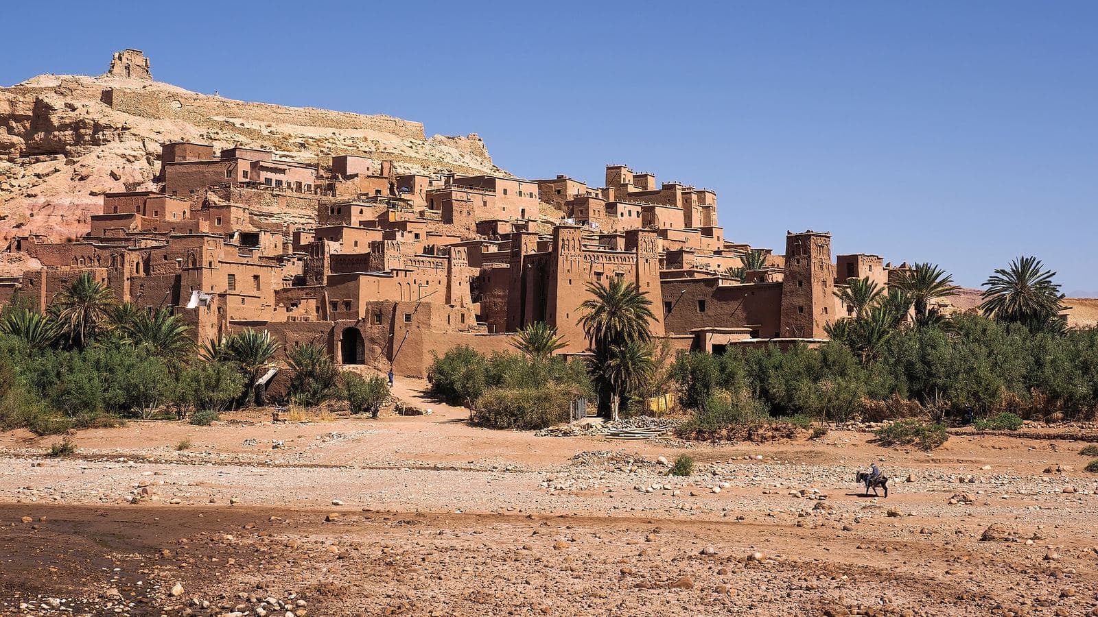 The earth-built ksar of Aït Benhaddou with palm trees in the foreground