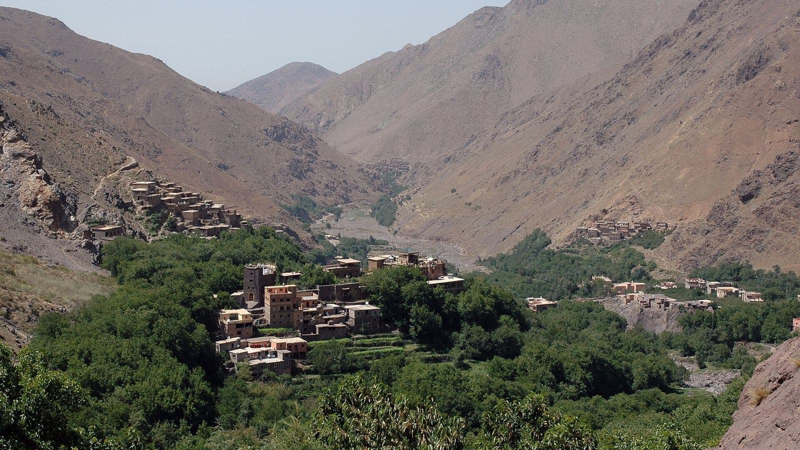 Earthen Berber village surrounded by walnut trees in a High Atlas valley near Marrakech