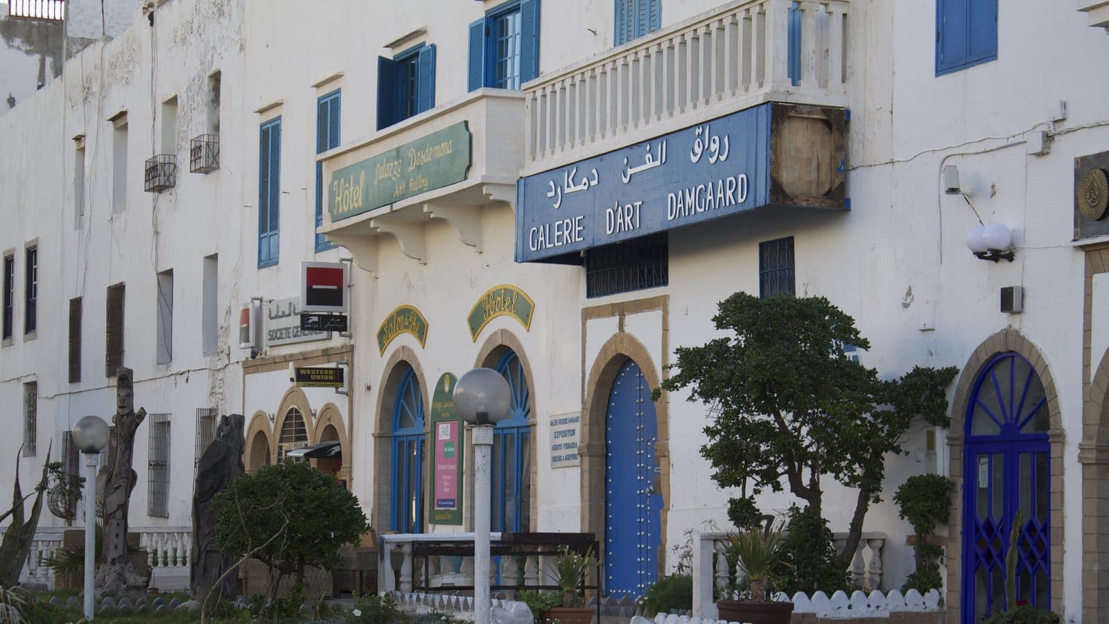 White façade with blue doors of the Galerie d’Art Damgaard in Essaouira