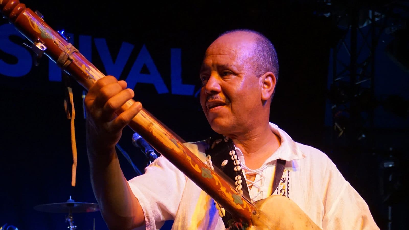 Moroccan musician Majid Bekkas playing the guembri on a festival stage