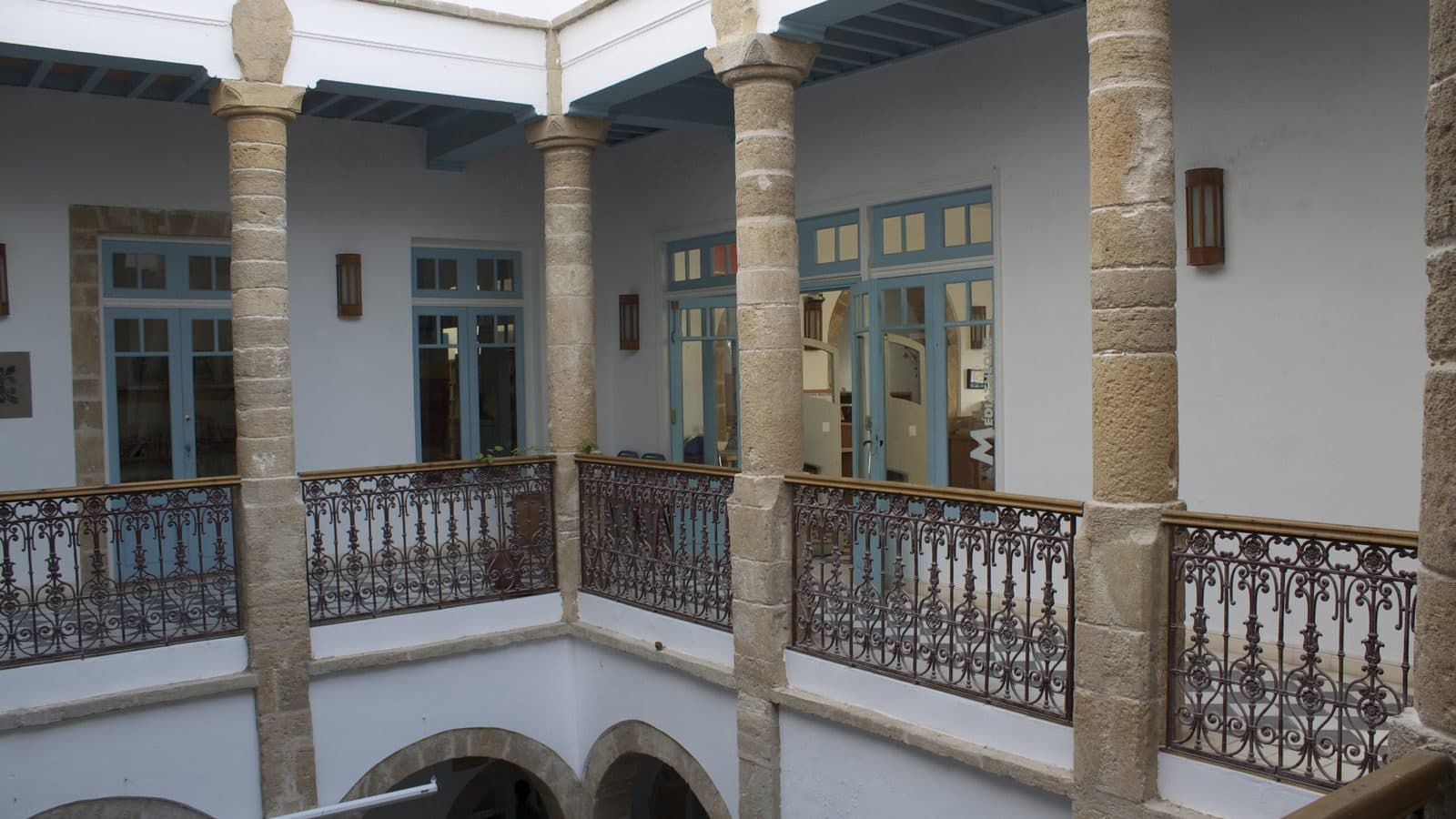 Arcaded courtyard with wrought-iron balconies in an old medina house in Essaouira