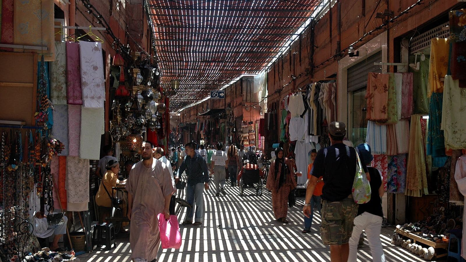 Shoppers walking through a covered souk in the Marrakech medina