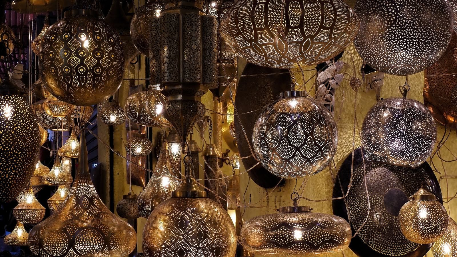 Des lanternes en métal ouvragé illuminant une boutique des souks de Marrakech