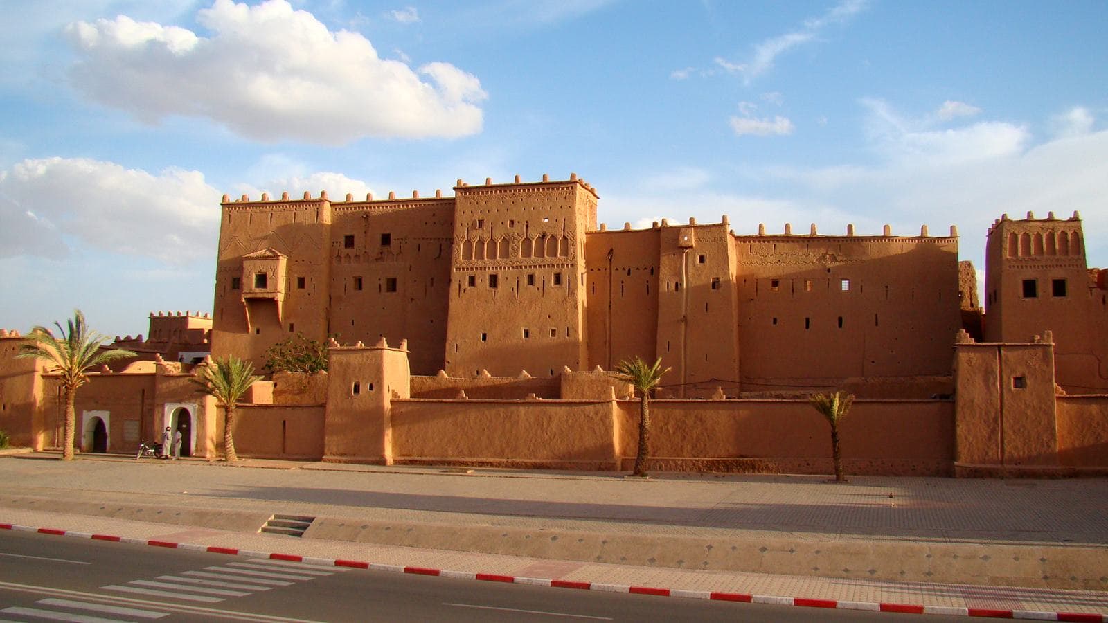The earthen towers of the Taourirt Kasbah in Ouarzazate under a blue sky