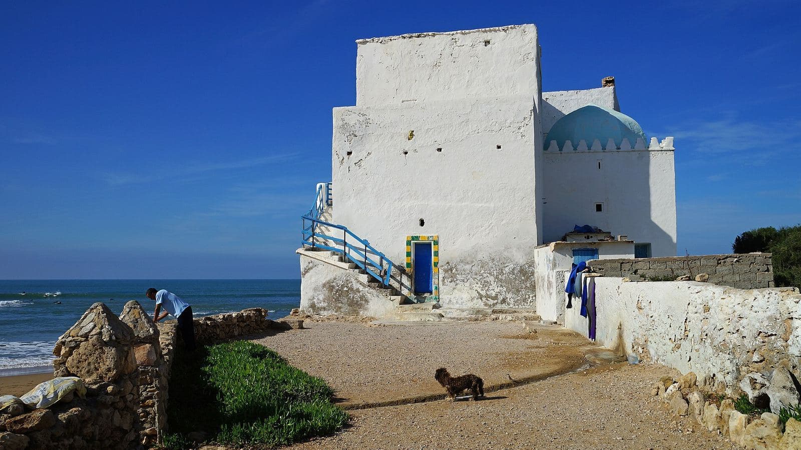 The whitewashed shrine of Sidi Kaouki with its blue dome above the Atlantic beach