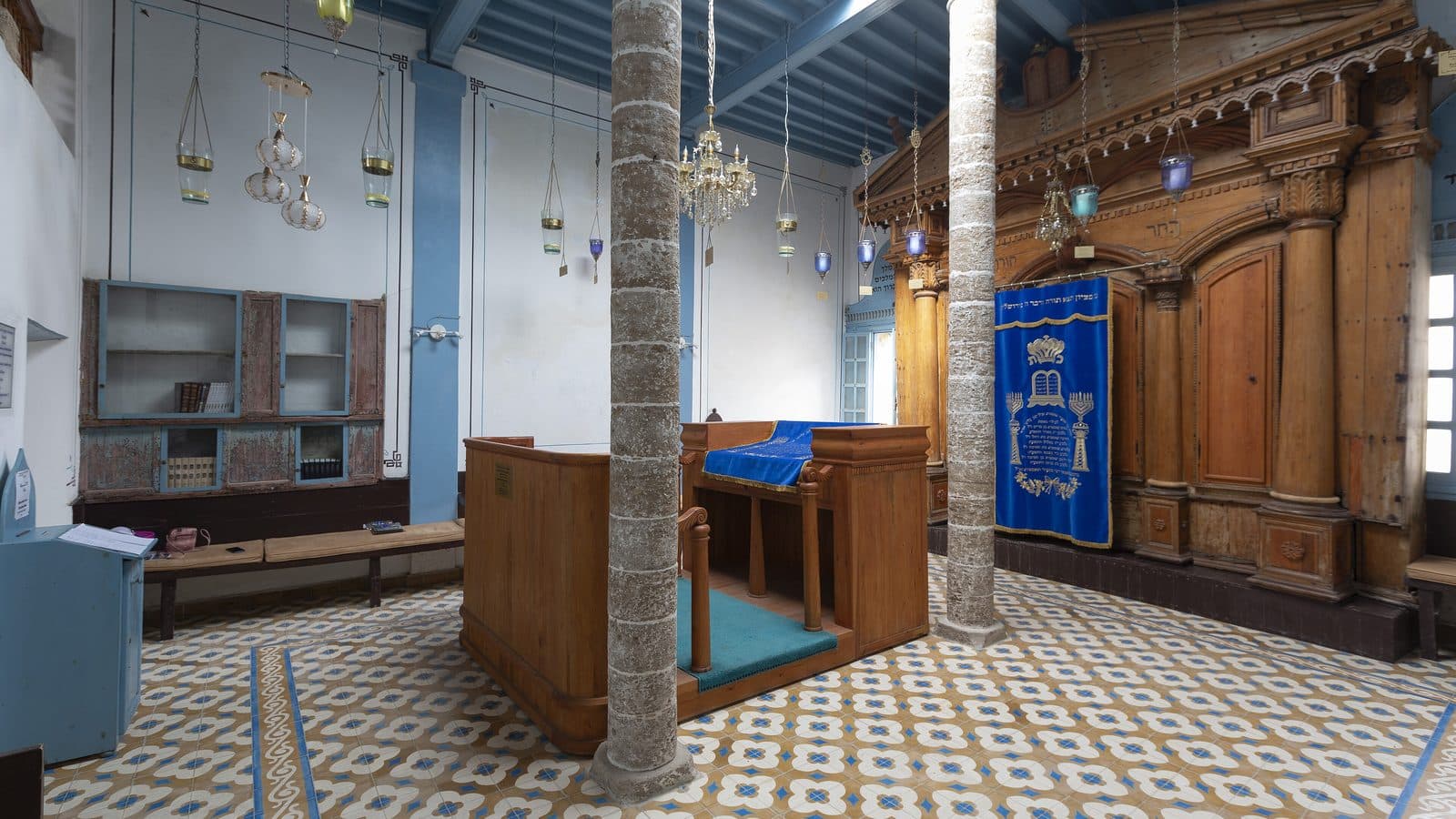 L'intérieur de la synagogue Slat Lkahal à Essaouira, avec son arche en bois sculpté, ses murs bleus et son sol carrelé