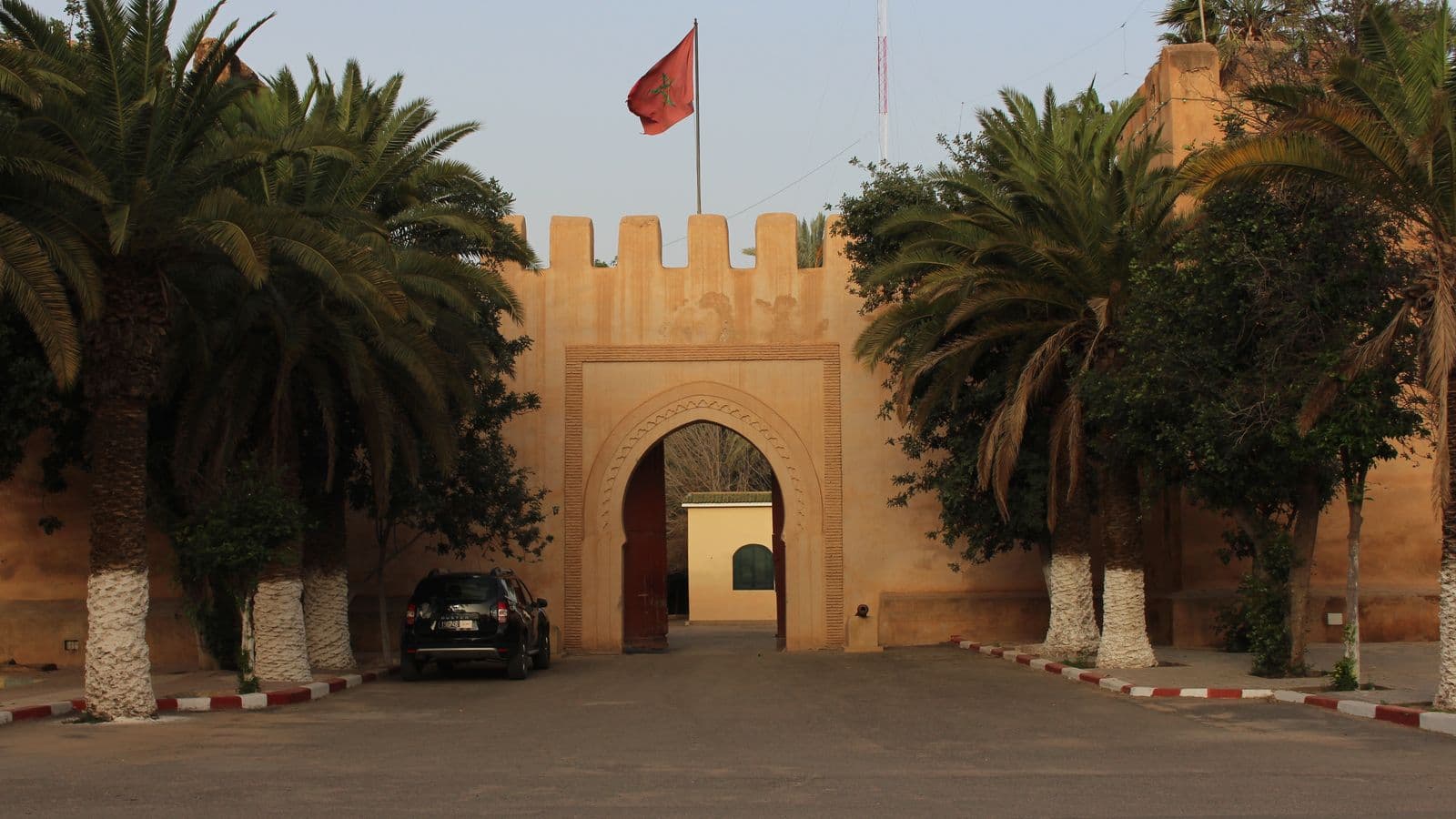 A crenellated ochre gateway with palm trees in Taroudant