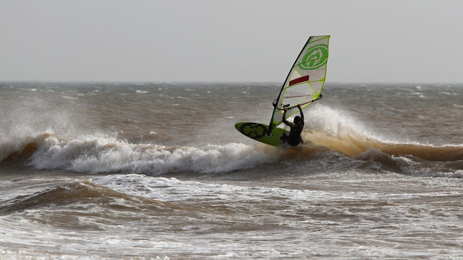 Windsurfer jumping off a breaking wave at Moulay Bouzerktoun near Essaouira