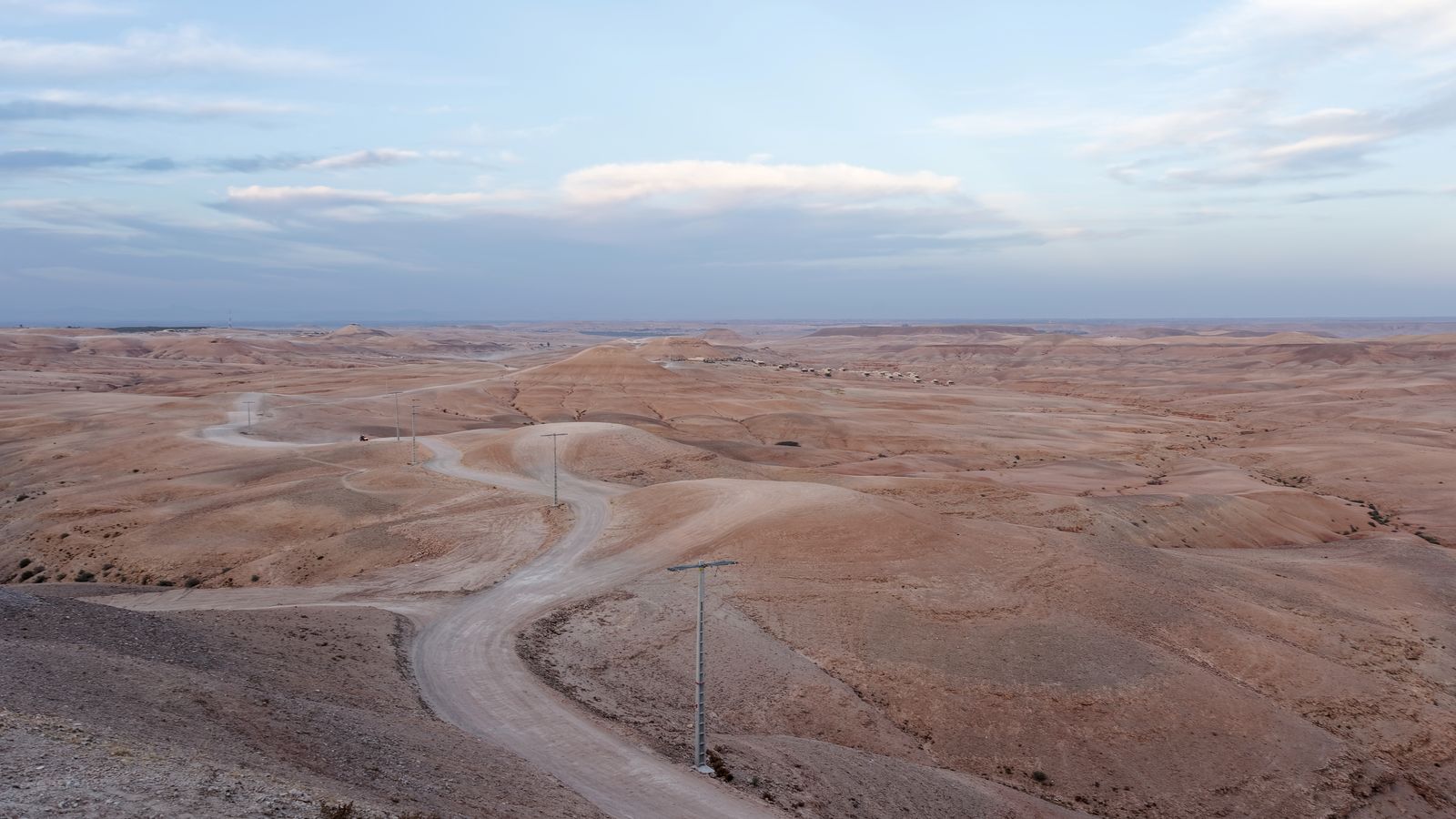 Les collines nues et ondulées du désert d'Agafay traversées par une piste
