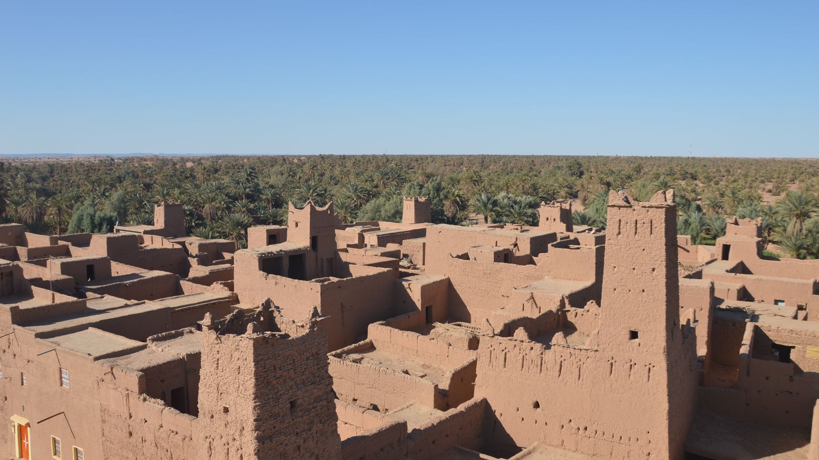 Earth-built kasbah towers above the palm groves of the Draa valley