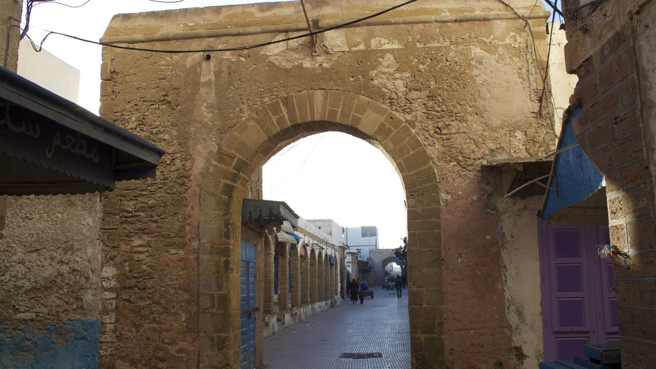 Une arche en pierre menant à une ruelle de la médina d'Essaouira