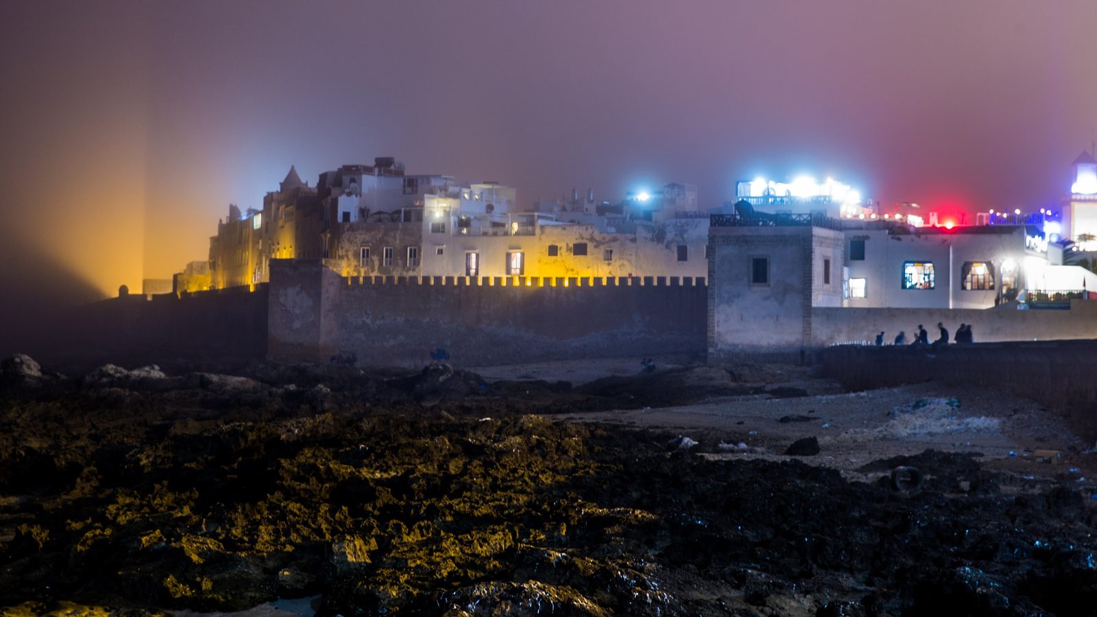 Essaouira's sea walls lit up on a misty winter night