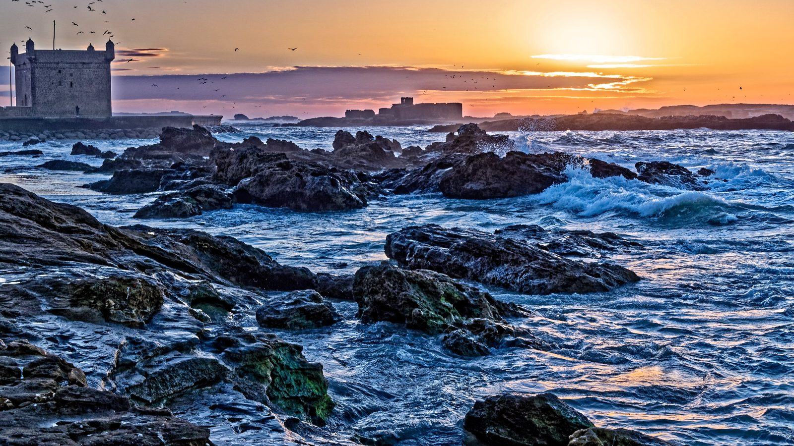Vagues se brisant sur les rochers au pied de la Skala au coucher du soleil