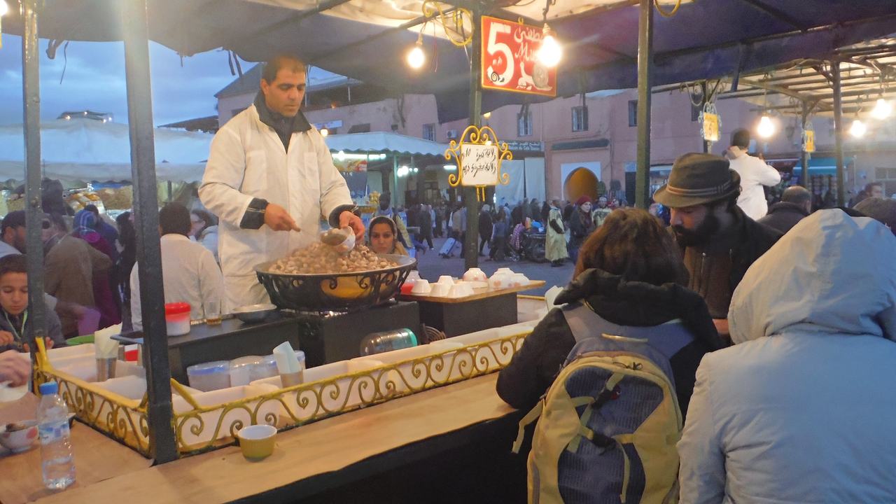A cook serving at a food stall in Jemaa el-Fnaa at night