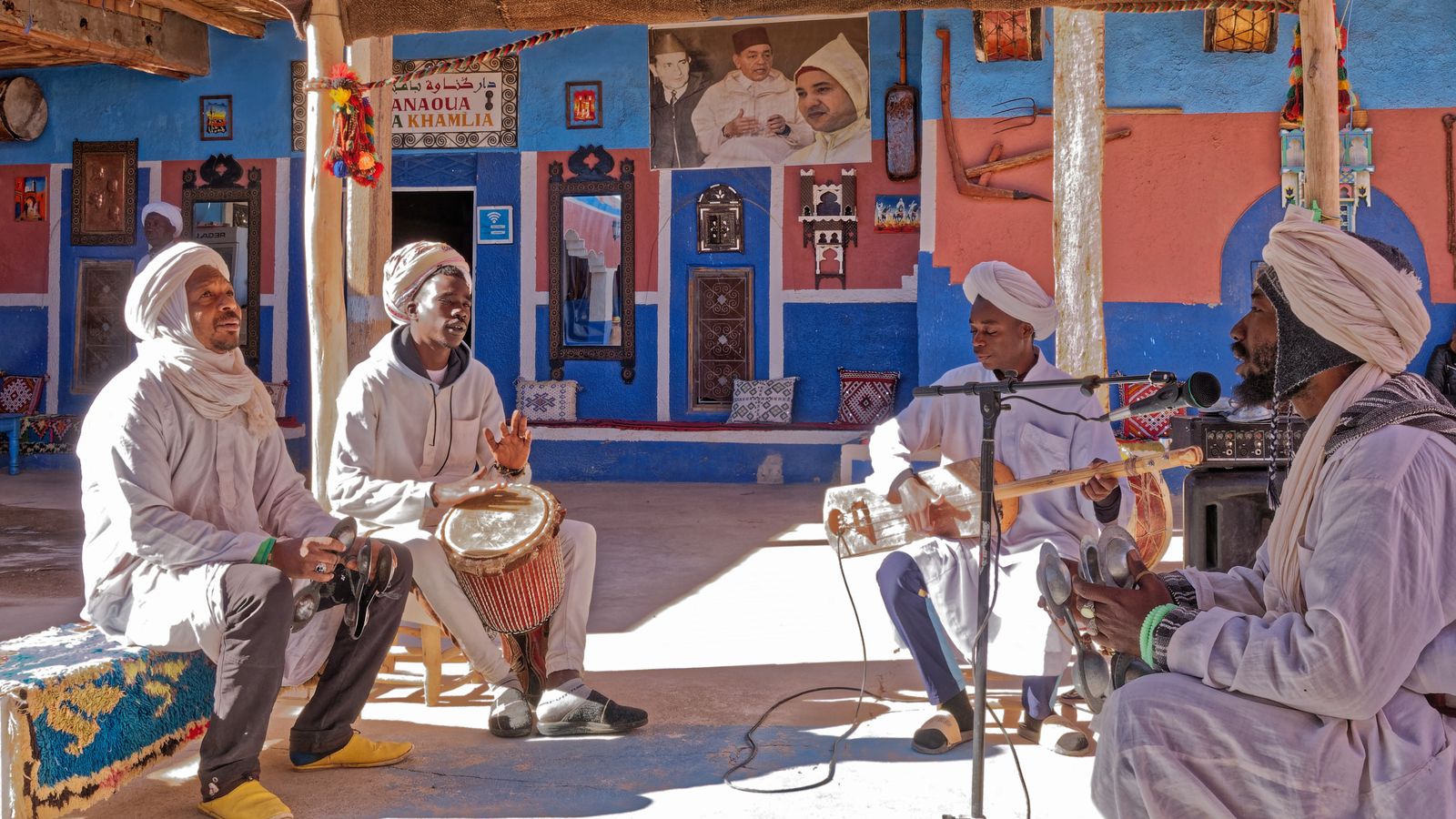 Musiciens gnawa en tenue blanche jouant dans le village de Khamlia
