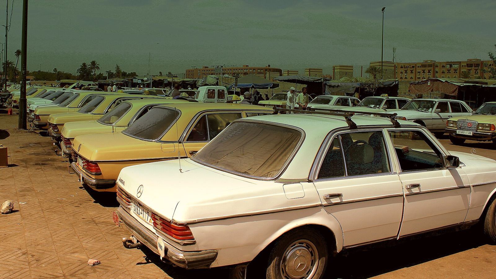 Rangées de grands taxis Mercedes attendant à une station de taxis au Maroc